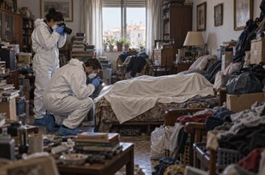Recreación de dos técnicos forenses examinando un cuerpo cubierto en una vivienda con acumulación extrema.